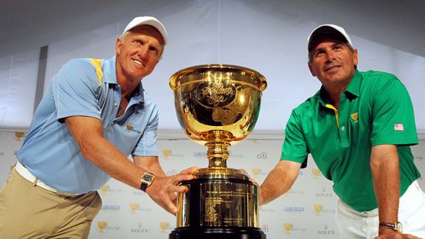 Greg Norman and Fred Couples pose with the trophy after a media conference at the Royal Melbourne golf course yesterday.