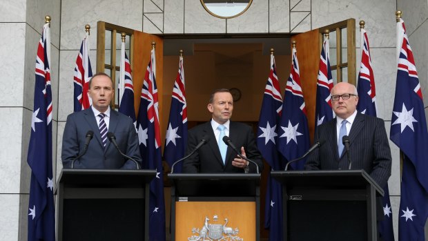 Ten-flag event:  Peter Dutton, Tony Abbott and George Brandis at a press conference at Parliament House on Tuesday.