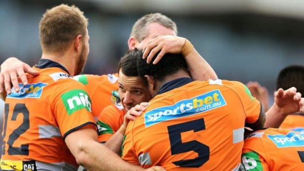 Together: Knights players embrace after a try against the Wests Tigers on Sunday.