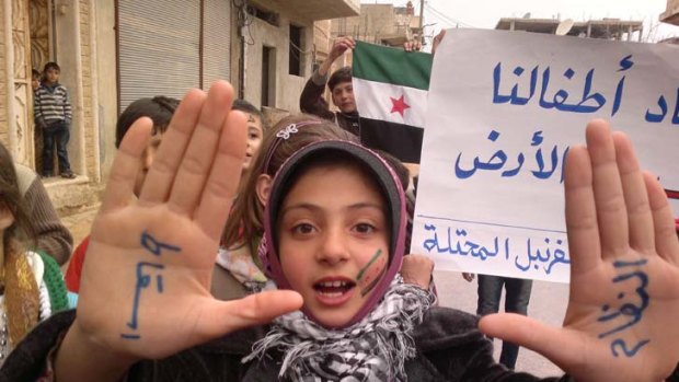 "Step down the regime" ... a girl, with this slogan written on her palms, takes part in a protest against Syria's President.