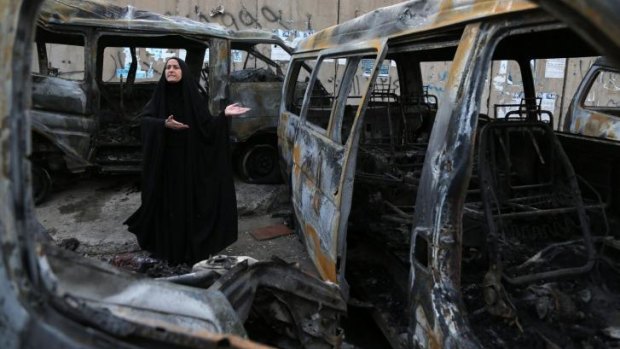 A woman amid the carnage at the site of a car bomb in the Shula neighbourhood of Baghdad. It was one of several attacks on civilians in Iraq over the weekend.