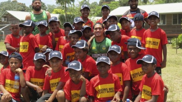 Local heroes: Prime Minister's XIII players Sione Mata'utia (centre) and Josh Mansour (top left) with young fans in Rabaul.