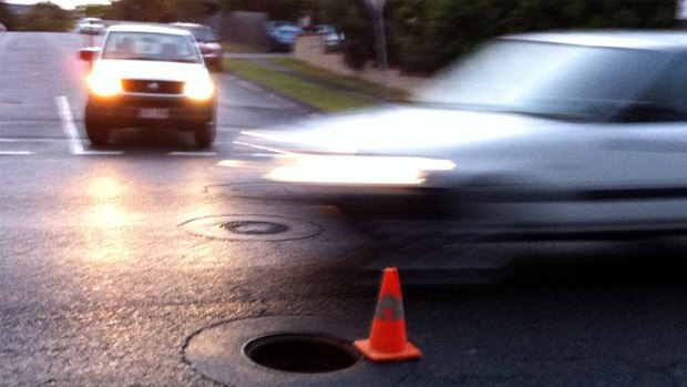 A traffic cone marks a missing manhole cover on Cavendish Road at Coorparoo.