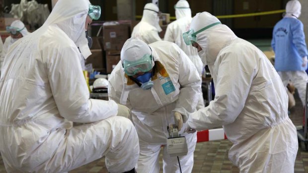 Radiation scanning crews check eath other's levels as they change their working shift at a screening centre in Koriyama in Fukushima.