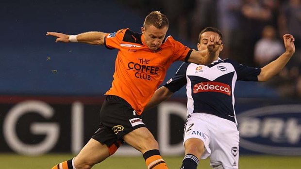 Besart Berisha of the Roar and Matthew Foschini of the Victory tussle for the ball.