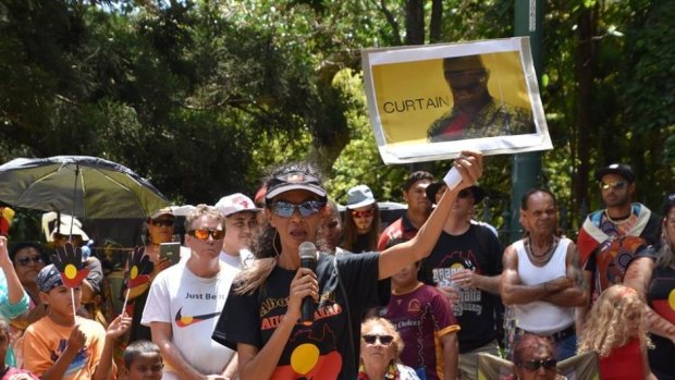 Gwenda Stanley holds up an image in support of Kevin Henry at a recent Invasion Day rally.