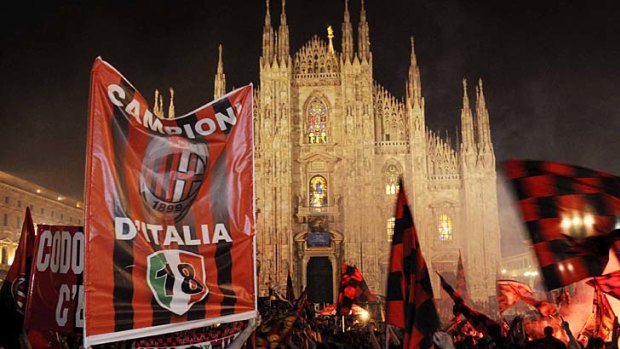 AC Milan fans celebrate in front of Milan's gothic cathedral.