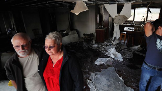 David and Marilyn Langmead of Strathewen inside the burnt-out Yarrambat house they were renting. They lost their own home to the Black Saturday blaze.