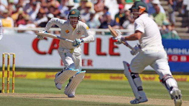 Australian captain Michael Clarke, left, makes a run with teammate, David Warner during the opening day of the third cricket test match against South Africa in Cape Town.