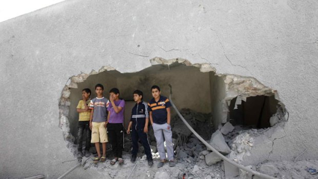 Deadly accuracy ... children stand amid the rubble of the destroyed Gaddafi family compound in Tripoli.