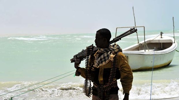Part pirate, part armed militia, a Somali carries his high-calibre weapon along a beach in the central Somali town of Hobyo, a former Italian port.