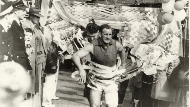 Footscray captain Charlie Sutton leads his club out on Grand Final day in 1954. His Bulldogs were victorious, but the club has not won a premiership since.