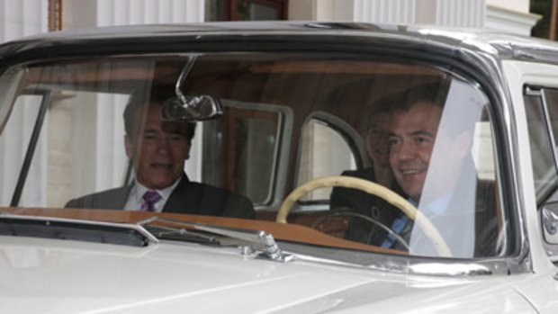 Dmitry Medvedev takes Arnold Schwarzenegger for a spin in a Soviet Chaikain car.
