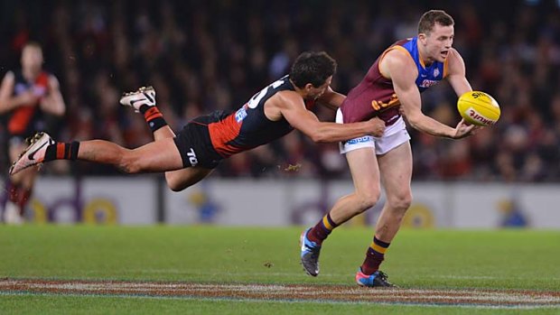 Desperately trying to hang on ... Pearce Hanley is tackled by Essendon's Mark Baguley.