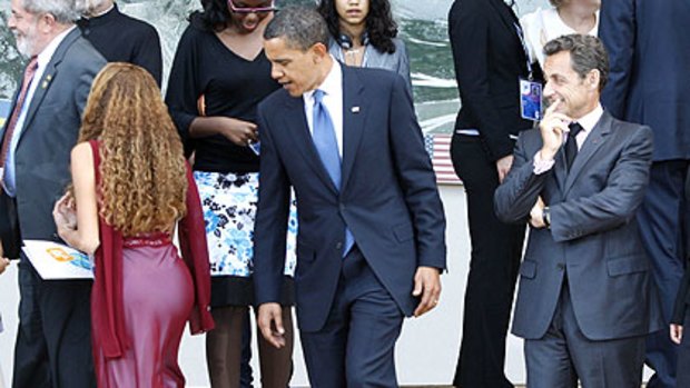 Barack Obama and Nicolas Sarkozy take their places with junior delegates, including Brazil's Mayora Tavares (left) for a photograph at the G8 summit.