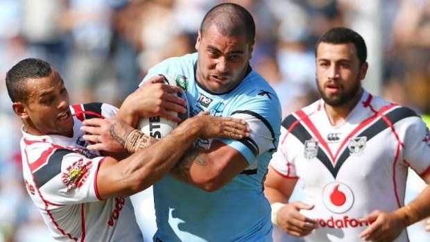 Ball and all: Cronulla's Andrew Fifita is wrapped up by the Warriors' Jayson Bukuya.