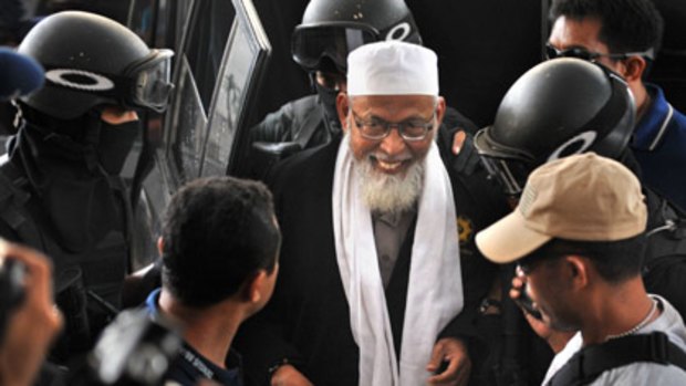 Elite anti-terror police escort controversial Islamic cleric Abu Bakar Bashir at police headquarters in Jakarta.