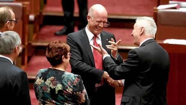 LDP Senator David Leyonhjelm is congratulated by Senator Doug Cameron after delivering his first speech in the Senate at Parliament House in Canberra.