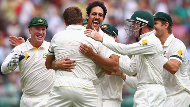 Mitchell Johnson of Australia celebrates celebrates after taking the wicket of Alastair Cook.