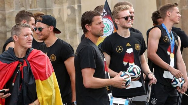 Germany's midfielder Bastian Schweinsteiger, defender Shkodran Mustafi, goalkeeper Roman Weidenfeller, midfielder Andre Schuerrle and defender Erik Durm arrive for a victory parade at Berlin's landmark Brandenburg Gate on Tuesday.