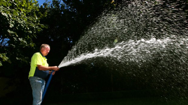 Don Dawson sprays $300 worth of water on to the lawn of a Toorak showbusiness mogul this week.