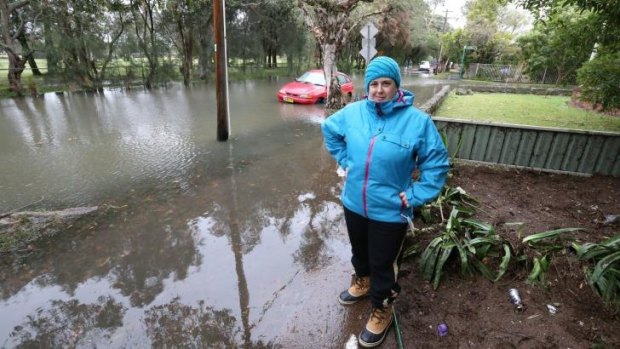 Claire Smith beside the flooded Cooks Rover at Marrickville.