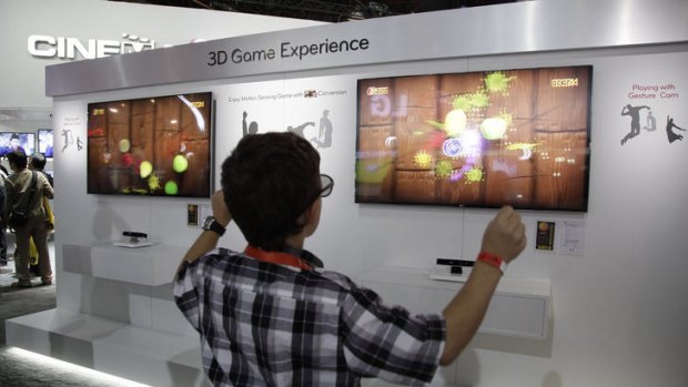 A boy plays with a motion sensing 3D version of the video game Fruit Ninja at the LG exhibit at CES.