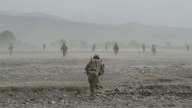 A US soldier walks with Afghan troops during a patrol at Combat Outpost in Sabari, Khost province.