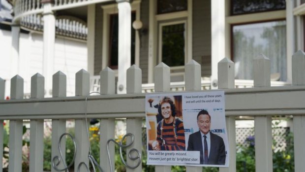 A photo of Robin Williams' Mork character is left at an impromptu memorial set up outside the house used in his breakout hit TV series.