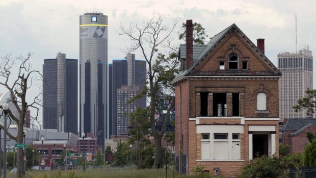 A boarded up house in front of the Detroit city skyline