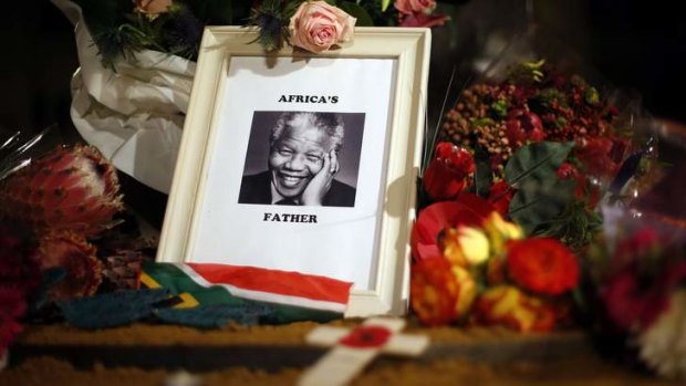 Flowers and tributes are left on the Nelson Mandela statue on Parliament Square in London.