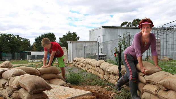 Ethan Low and Debbie Hawkins place sandbags around her house on the outskirts of Nathalia.