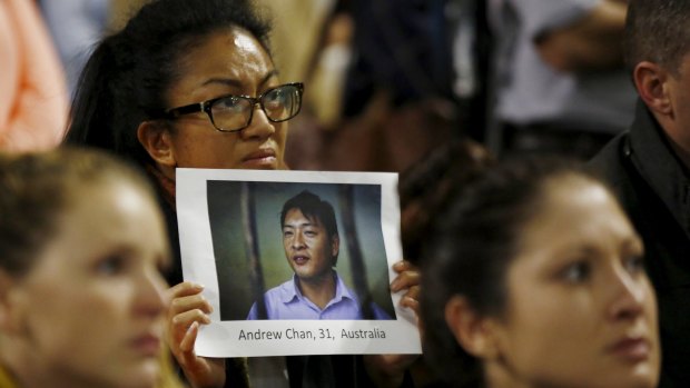 A supporter of Andrew Chan holds a picture of him at a vigil in Sydney on Tuesday.