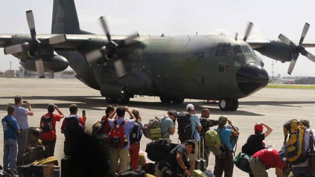 Local and foreign medical teams prepare to board a Philippines air force C-130 transport plane in Manila.