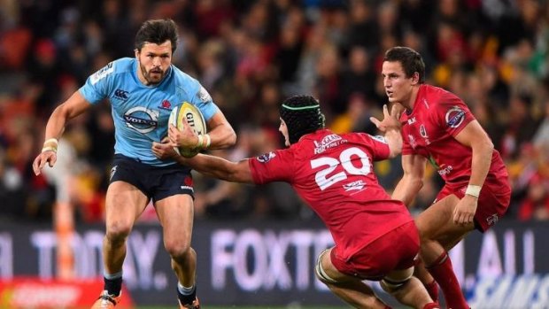Adam Ashley-Cooper of the Waratahs skips past Liam Gill of the Reds during Saturday's match.