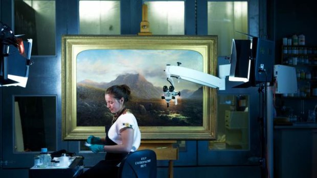 The Age, News. Restoration of a scottish painting at The NGV.restorer Sandi Mtchell with the scottish painting "Entrance to Glen Etive from near Kings house".Pic Simon Schluter  31 March 2014.