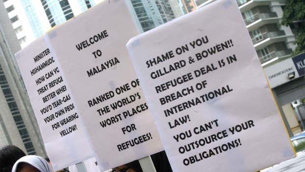 Malaysian human rights activists hold placards as they protest during the signing ceremony between Malaysia and Australia in Kuala Lumpur.