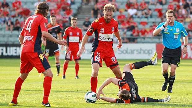Grounded: Roar frontman Besart Berisha falls during a tackle in front of Adelaide's Iain Fyfe.