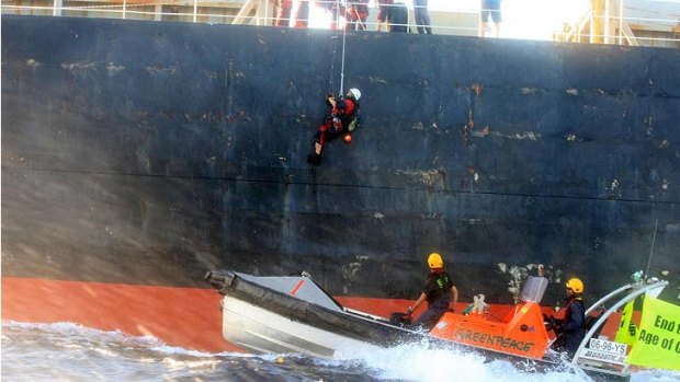 Greenpeace activists board a ship in the Coral Sea.