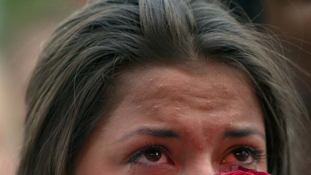 Remembering the dead ... Elizabeth Amundsen, 16, holds a rose as thousands of people gather at a memorial vigil.