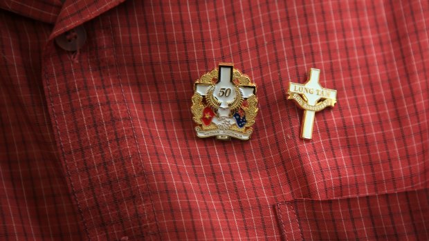 Anniversary lapel pins are worn on the shirt of Australian veteran Keith Payne.