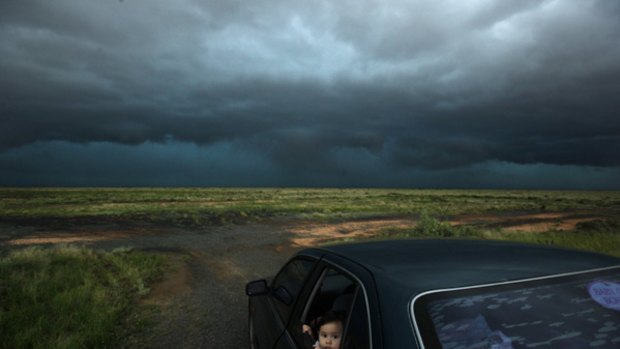 Should I wind up the window, Mum? … Jimelle Deguara watches a hailstorm break over the Hay region.