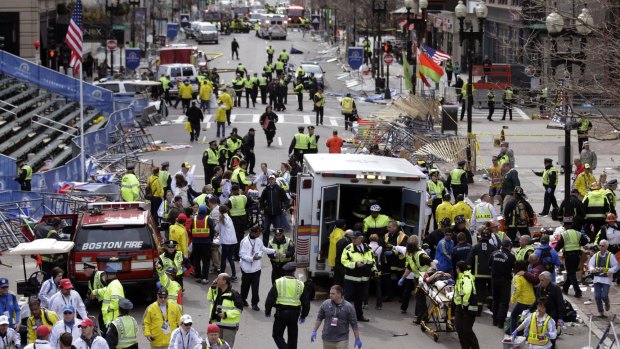 Medical workers aid injured people following the explosion at the finish line of the 2013 Boston Marathon in Boston. 