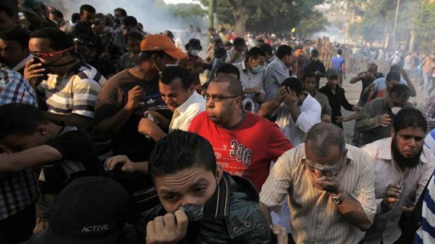 Members of the Muslim Brotherhood and supporters of ousted Egyptian President Mohamed Mursi run from tear gas released by riot police during clashes in Cairo.