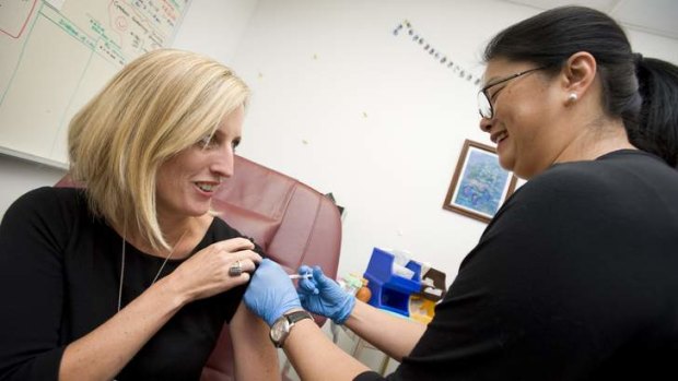 ACT Chief Minister and Minister for Health, Katy Gallagher, receives her flu vaccination from clinical nurse Joyce Ho-Chinn.