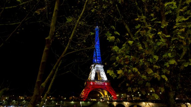 The illuminated Eiffel Tower in the French national colors red, white and blue in honor of the victims of the terrorist attacks last Friday, and Seine river are seen in Paris, Tuesday, Nov. 17, 2015. France is demanding security aid and assistance from the European Union in the wake of the Paris attacks and has triggered a never-before-used article in the EU's treaties to secure it. (AP Photo/Peter Dejong)