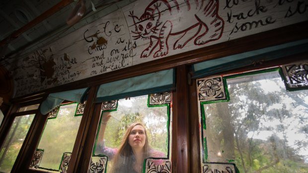 Karina Castan peers through the windows of Mirka Mora's art tram.