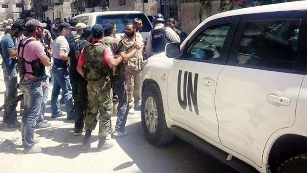 Syrian rebels with UN inspectors in Zamalka, east of Damascus. US officials say they expect the inspectors to leave Syria on Saturday.