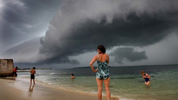 Cally Bruer and daughter Martha, right, watch a shelf cloud over Yarra Bay yesterday.
