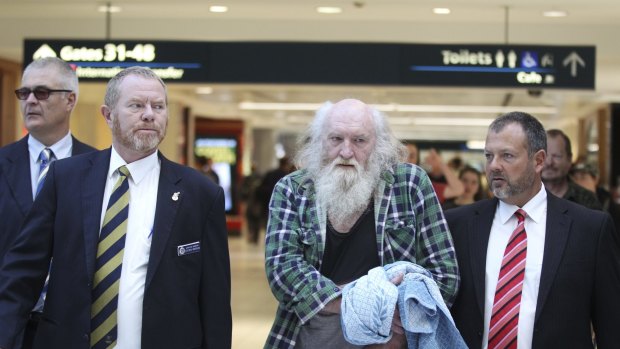 Arrest: Colin Michael Newey is escorted by police on Thursday at Sydney Airport.